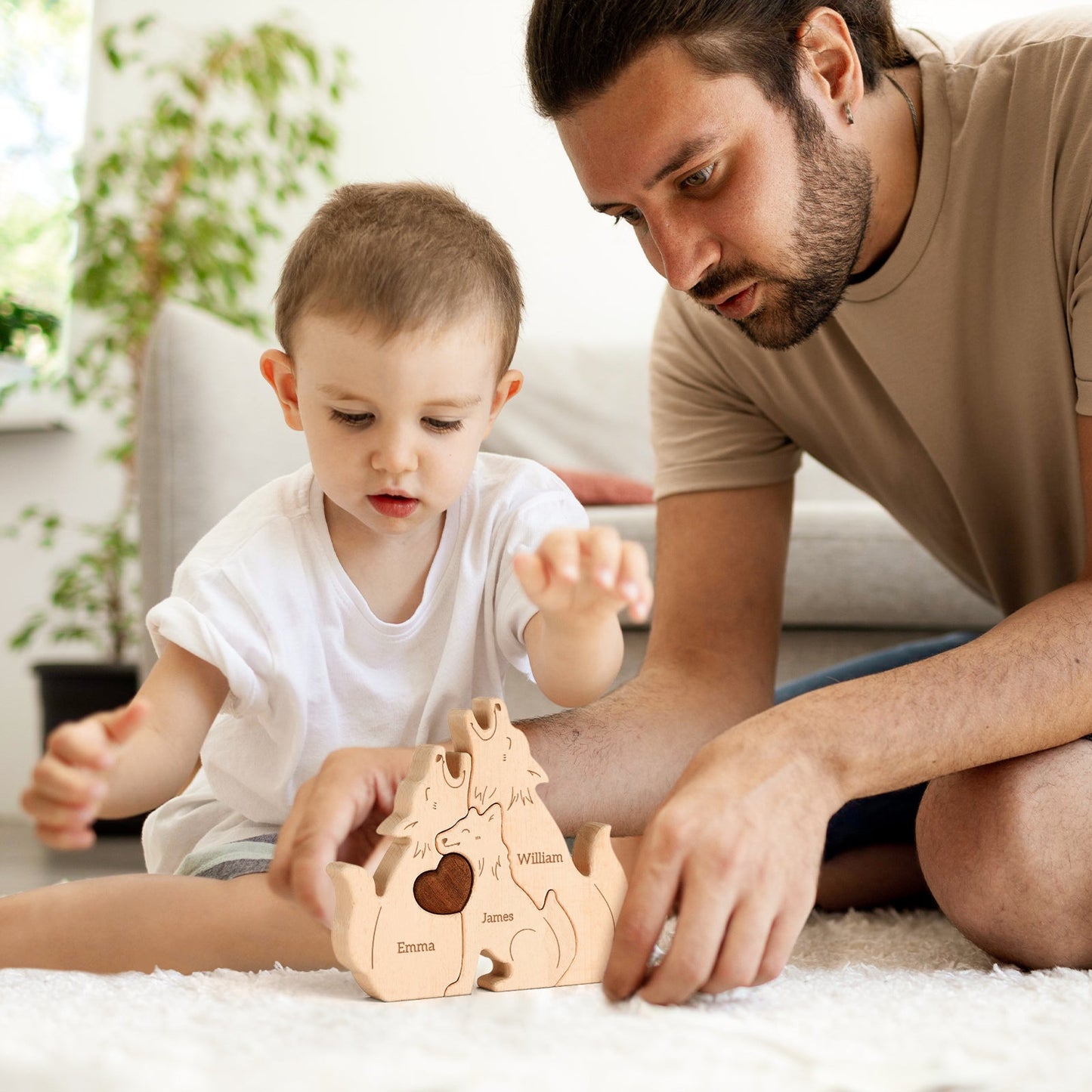 Father and son playing with a personalized wooden wolf family puzzle, showcasing carved names and family togetherness.