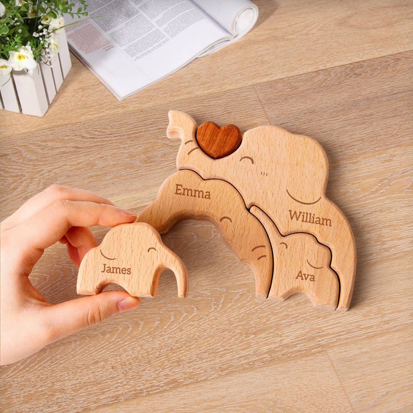 Personalized wooden elephant family puzzle featuring names Emma, William, Ava, and James on a home decor table.