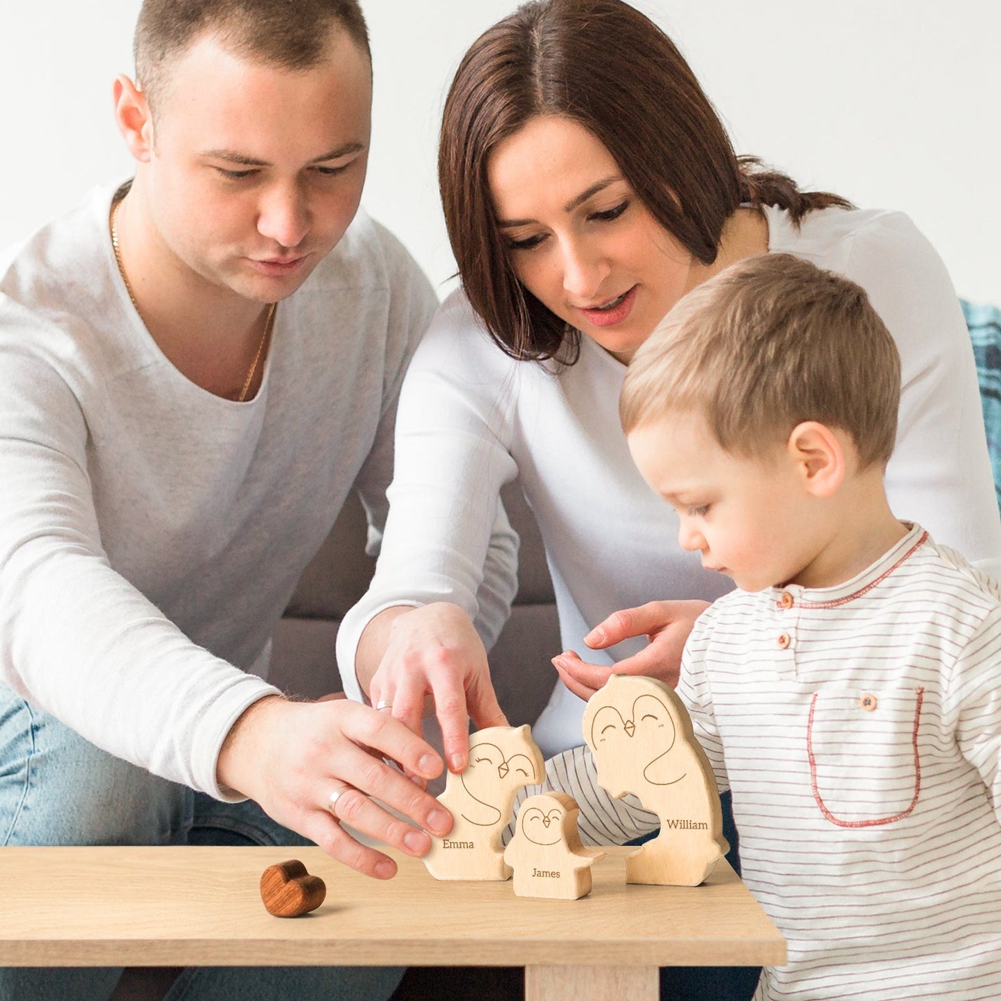 Family enjoying personalized wooden penguin puzzle with carved names, showcasing love and togetherness.
