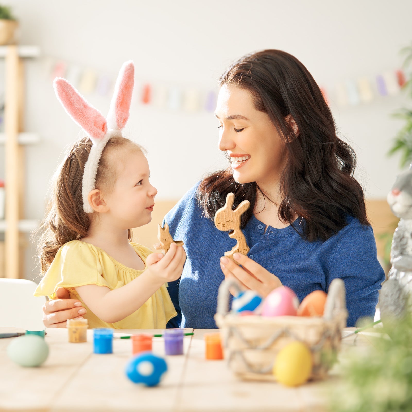 Mom and daughter enjoying crafting personalized wooden rabbit puzzles together, highlighting family bonding.