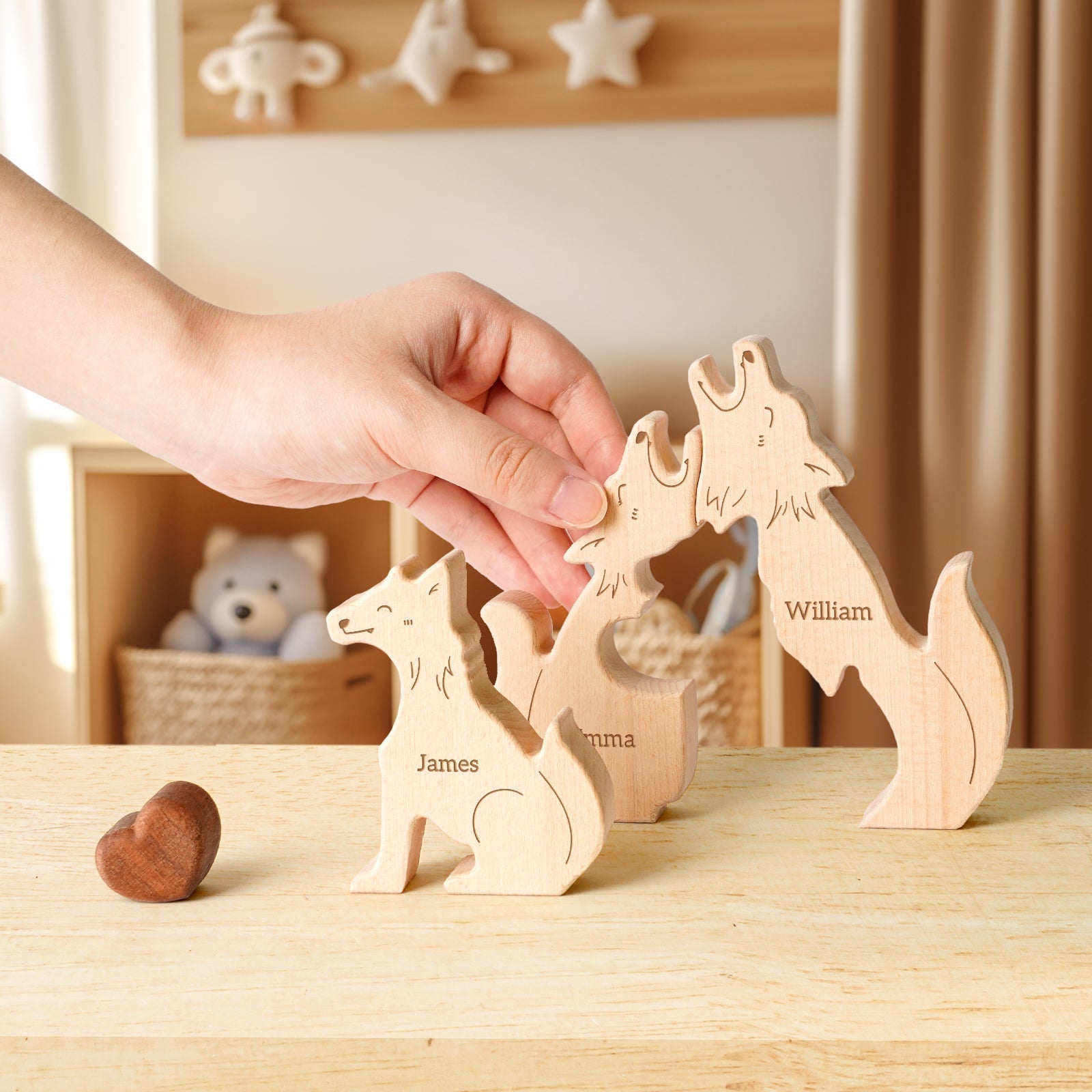 Hand placing personalized wooden wolf family puzzle pieces with names James, Emma, and William on a table.