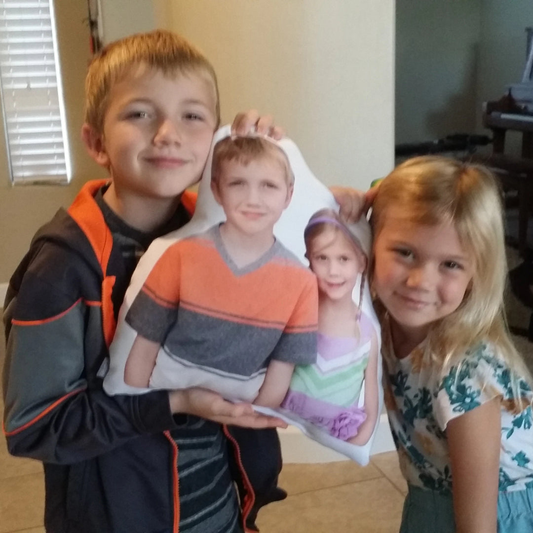 Kids holding a personalized funny pillow featuring their own photos, showcasing a creative and unique gift option.